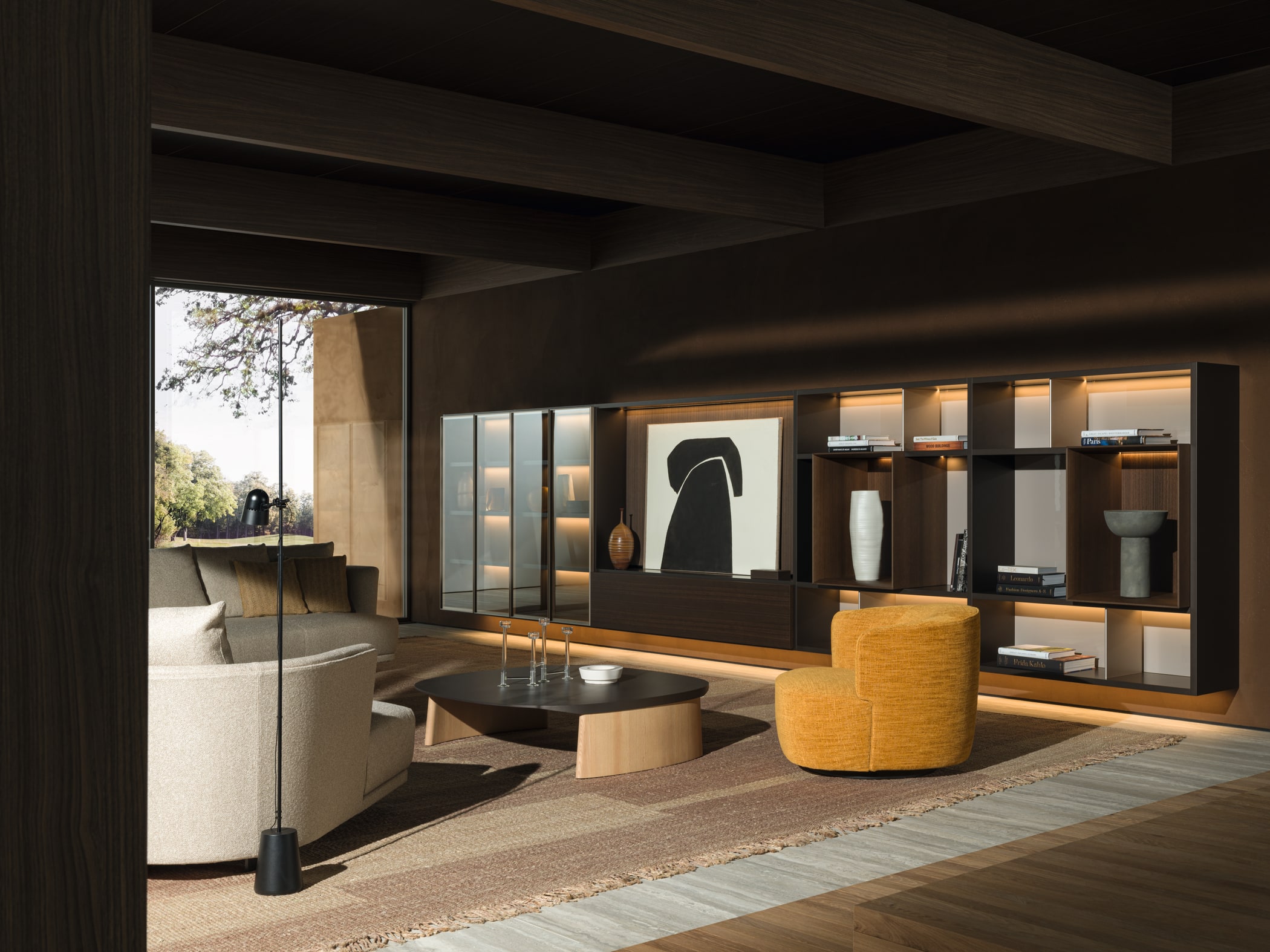 Гостиная Molteni&C: светлый диван Cleo, жёлтое кресло Elain, тёмные столики и система хранения на деревянной стене