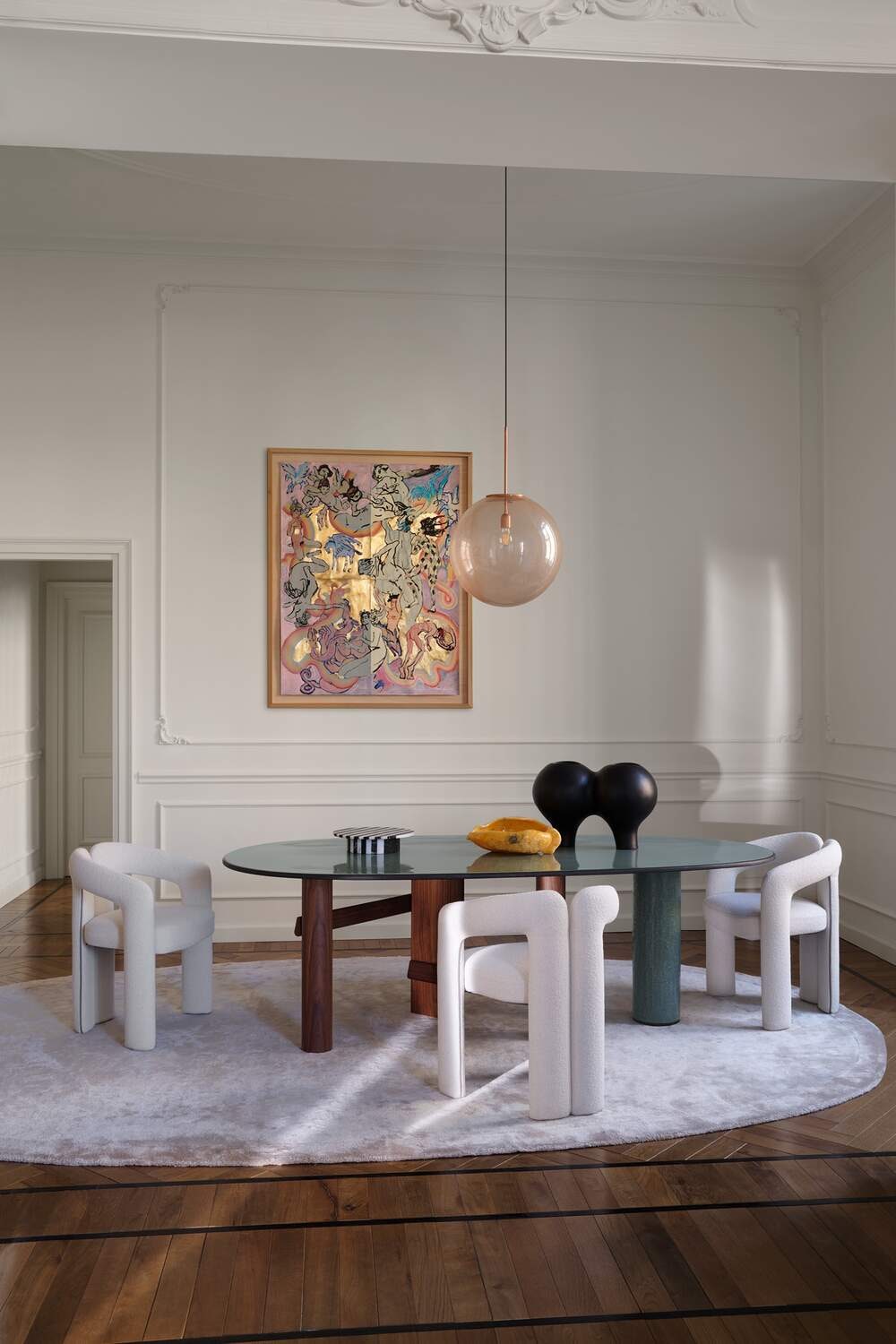 Светлая столовая с овальным столом Cassina Sengu Table, мягкими креслами и подвесным светильником